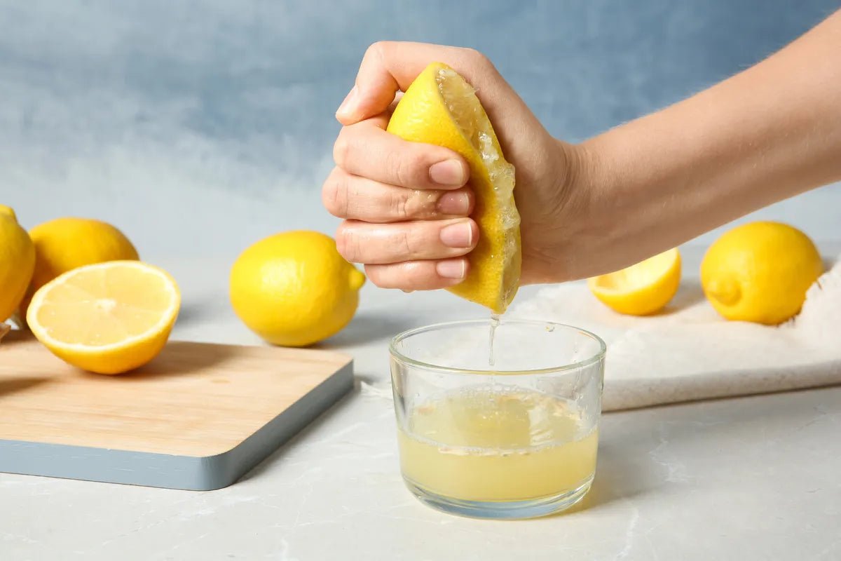 Verre de jus de citron pressé et citrons frais